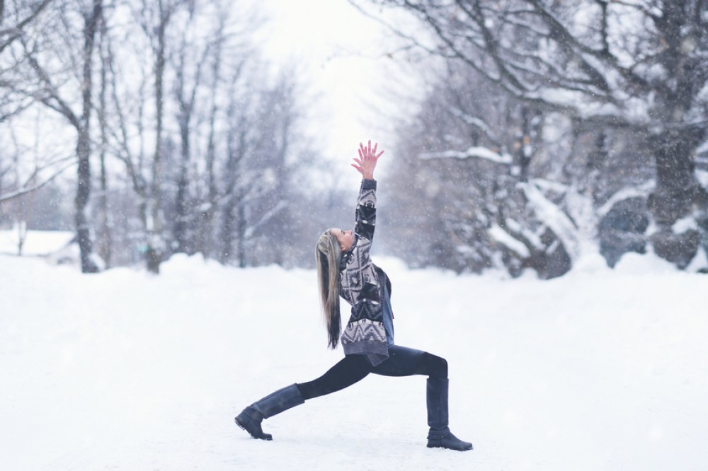 Woman in snow doing yoga